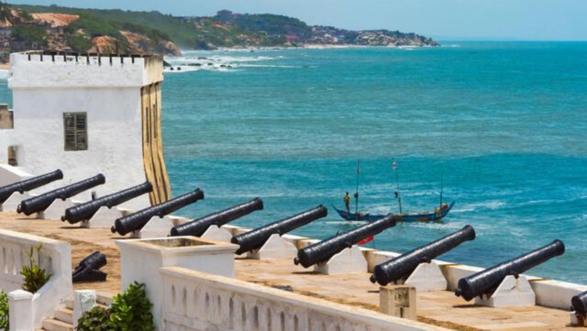 The historic whitewashed walls and cannons of Cape Coast Castle overlooking the Atlantic Ocean in Ghana