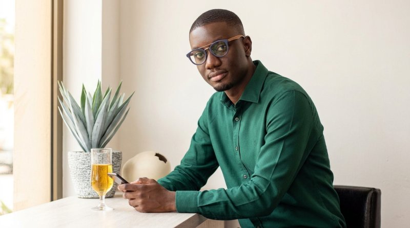 Editorial shot of Ghanaian entertainment blogger Ameyaw Debrah wearing an emerald green shirt